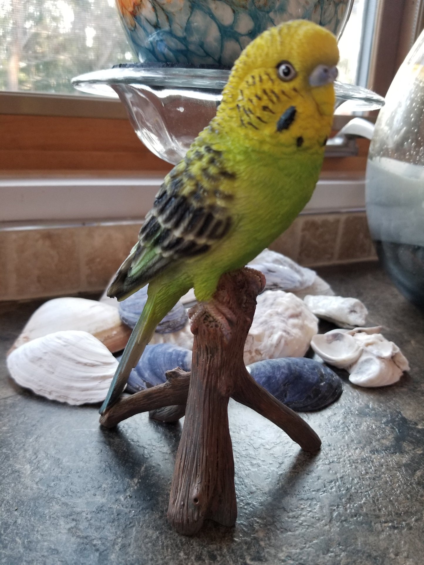 budgie on a branch statue